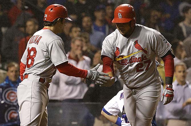 St. Louis Cardinals' Jhonny Peralta, right, celebrates with Pete Kozma after hitting a two-run home run during the ninth inning of a baseball game against the Chicago Cubs Wednesday, July 8, 2015, in Chicago. 