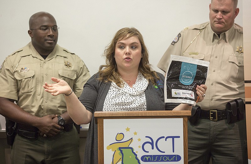 Natalie Newville, a public information officer at ACT Missouri, center, explains the function of the new Deterra drug disposal bags and how they will be used in Jefferson City and surrounding communities during a press conference at the Cole County Sheriff's Office. Unused prescription medications can be dumped into large bags at pharmacies, or personal one-time use bags, which require the addition of water to neutralized drugs. After that, the bag can be sealed and thrown away.