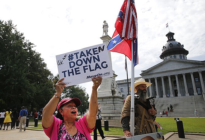 Maria Calef, of Columbia, South Carolina, waves a sign Thursday as she celebrates in front of the South Carolina statehouse. More than 50 years after South Carolina raised a Confederate flag, the rebel banner is scheduled to be removed this morning.