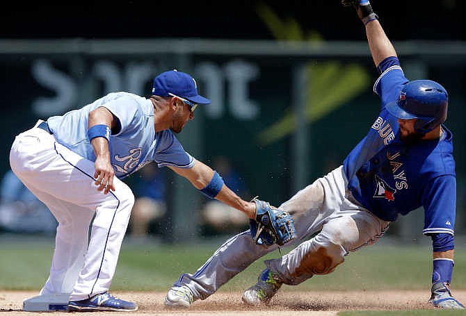 Kansas City Royals second baseman Omar Infante, left, tags out Toronto Blue Jays' Russell Martin, right, during the sixth inning of a baseball game at Kauffman Stadium in Kansas City, Mo., Saturday, July 11, 2015. Martin was caught stealing on the play.