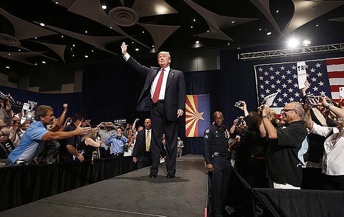 Republican presidential candidate Donald Trump waves to the crowd as he arrives to speak at a rally before a crowd of 3,500 Saturday, July 11, 2015, in Phoenix.