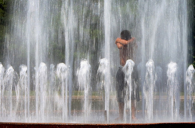 William Reece, of St. Louis, stands in a fountain outside the World's Fair Pavilion at Forest Park, Monday,in St. Louis. The National Weather Service has issued an excessive heat warning for parts of Kansas, Missouri, Iowa and Illinois. 