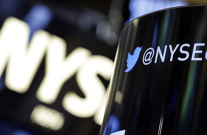 In this Monday, Nov. 4, 2013, file photo, a phone post on the floor of the New York Stock Exchange features a Twitter logo, in New York. Twitter's stock briefly spiked on Tuesday, July 14, 2015, after a fake story said the company received a $31 billion buyout offer.