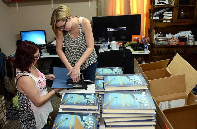 Jane MacAdam, far left, and Ginny Bordeaux emboss copies of "Go Set a Watchman" in Ol' Curiosities & Book Shoppe on the book's release date in the hometown of "To Kill a Mockingbird" author Harper Lee, in Monroeville, Ala.