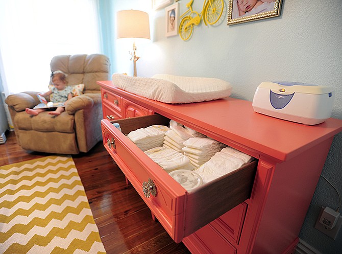 Rather than spending a fortune on all new furniture for their daughter's nursery, Brooks and Kris Crawford purchased a used dresser, seen at right, and gave it new handles and a fresh coat of paint to serve as a changing table. 