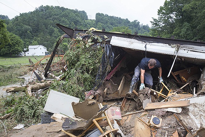 Roland Marcum looks for his brother-in-law Scott Johnson Wednesday under the debris of Marcum's father-in-law's mobile home after deadly flooding in Flat Gap, Kentucky. Family members have been looking for Johnson after he helped saved the lives of four family members but went missing during flash floods in northern Johnson County outside of Paintsville.