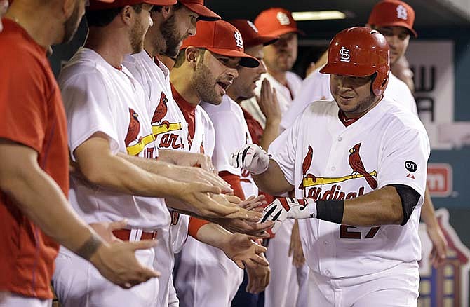 St. Louis Cardinals' Jhonny Peralta (27) is congratulated by teammates in the dugout after hitting a solo home run during the sixth inning of a baseball game against the New York Mets, Friday, July 17, 2015, in St. Louis. 