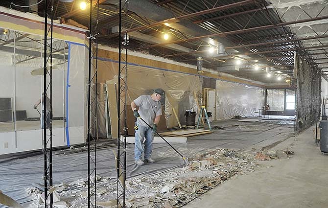 Perry Morgan sweeps up after demolishing the wall between Carrie's Hallmark and the
adjacent area that used to be a wig shop. That business suffered extensive damage in a fire
earlier this year. This extra space will expand Carrie's Hallmark in downtown Jefferson City by approximately one-third.