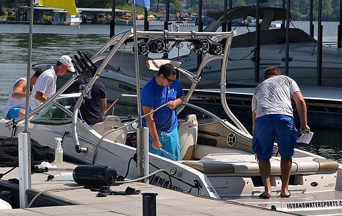 In this June 18, 2014 file photo, Iguana Watersports dock crew at the Lake of the Ozarks readies a boat for a customer. A change in Missouri law taking effect in August 2015 will eliminate the extra 17 cents in state motor fuel tax currently charged on each gallon of gas sold at on-the-water pumps.