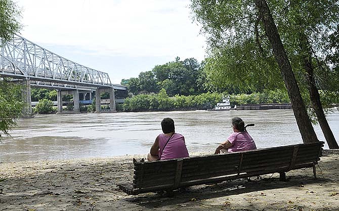 Mary Rossi, left, and Nancy Morey watch a sand barge go up river as they enjoy a visit Thursday to
the Missouri River at the Noren Access in north Jefferson City. Morey grew up around the Missouri River and appreciates the opportunity to sit and take in the sights and sounds.