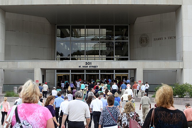 People flood back into the Harry S. Truman building after police signaled the area was safe Wednesday following a bomb threat that evacuated the building.