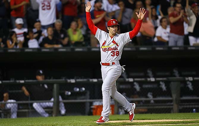St. Louis Cardinals shortstop Pete Kozma (38) reacts to a triple by teammate Yadier Molina while coming in to score a run during the eighth inning of a baseball game against the Chicago White Sox in Chicago, Wednesday, July 22, 2015. 