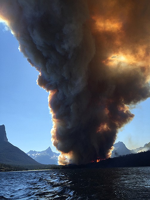 Smoke from the Reynolds Creek fire rises above the landscape Tuesday at St. Mary Lake in Glacier National Park, Montana. State Rep. Jenny Eck, who was hosting a delegation from Australia on a tour of the park, took this photo of the fast-moving wildfire. The flames torched a car and a historic cabin and forced tourists to abandon their vehicles on the park's most popular roadway while officials evacuated hotels, campgrounds and homes.