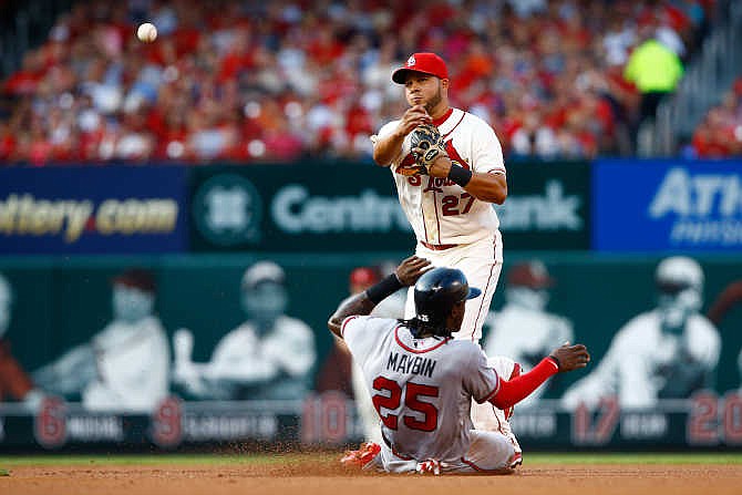 St. Louis Cardinals shortstop Jhonny Peralta, top, turns a double play over the slide of Atlanta Braves' Cameron Maybin during the third inning of a baseball game Saturday, July 25, 2015, in St. Louis.