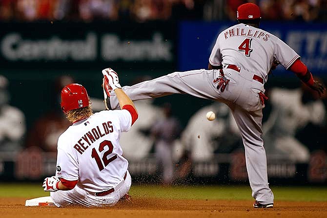 St. Louis Cardinals' Mark Reynolds, left, slides safely into second base under the foot of Cincinnati Reds second baseman Brandon Phillips after hitting a double during the seventh inning of a baseball game, Tuesday, July 28, 2015, in St. Louis. 