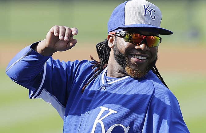 Kansas City Royals' Johnny Cueto stretches and smiles before the Royals play the Cleveland Indians in a baseball game, Tuesday, July 28, 2015, in Cleveland.