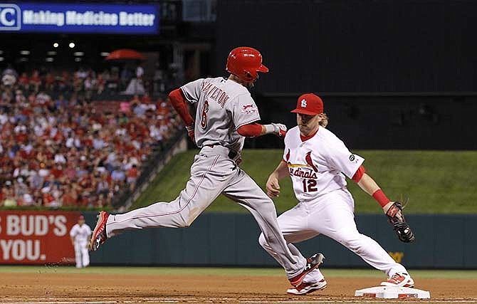Cincinnati Reds' Billy Hamilton, left, is forced out at first base by St. Louis Cardinals' Mark Reynolds on a bunt attempt during the fifth inning of a baseball game ,Wednesday, July 29, 2015, in St. Louis.