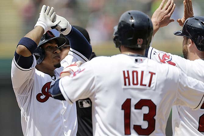 Cleveland Indians' Francisco Lindor, left, is congratulated by Tyler Holt and Jason Kipnis, right, after Lindor hit a three-run home run off Kansas City Royals starting pitcher Jeremy Guthrie in the sixth inning of a baseball game, Wednesday, July 29, 2015, in Cleveland. Holt and Kipnis scored on the play.