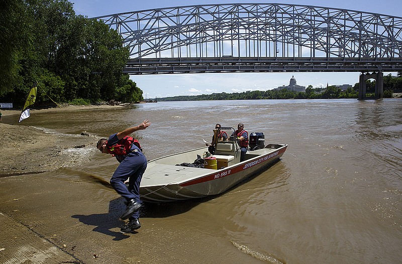 Jefferson City firefighters work to locate and give aid to a paddler suffering from heat issues Wednesday.