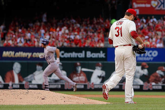 St. Louis Cardinals starting pitcher Lance Lynn , right, walks off the mound as Colorado Rockies' Nolan Arenado runs the bases after hitting a two-run home run during the fourth inning of a baseball game Saturday, Aug. 1, 2015, in St. Louis. 