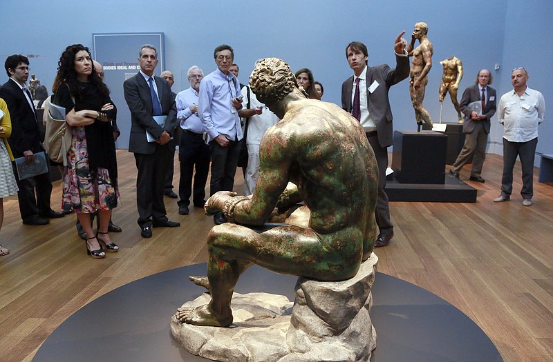 Jens Daehner, right, associate curator at the J. Paul Getty Museum, shows the media a sculpture titled "Terme Boxer, 3rd2nd century B.C." in the "Power and Pathos: Bronze Sculpture of Hellenistic World" exhibit in Los Angeles. The exhibit brings together more than 50 bronzes from the Hellenistic period that extended from about 323 to 31 B.C. 