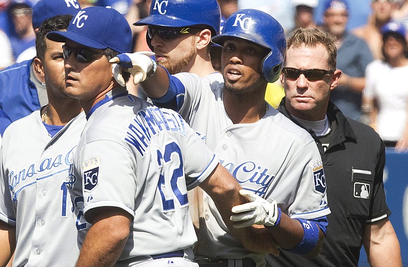 Alcides Escobar of the Royals gets held back by coach Don Wakamatsu (22) as he gestures at Blue Jays pitcher Aaron Sanchez during Sunday's game in Toronto. Sanchez was ejected from the game for hitting Escobar with a pitch. Looking on is home plate umpire Jim Wolf.