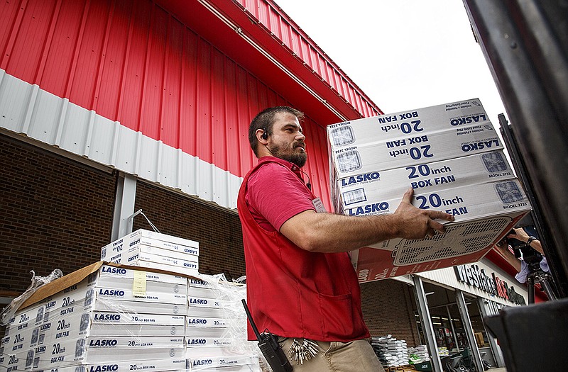 Westlake ACE Hardware employee Jason Barton loads a stack of box fans into a Salvation Army truck Wednesday at Westlake. The 71 fans are the result of a drive hosted by Westlake.