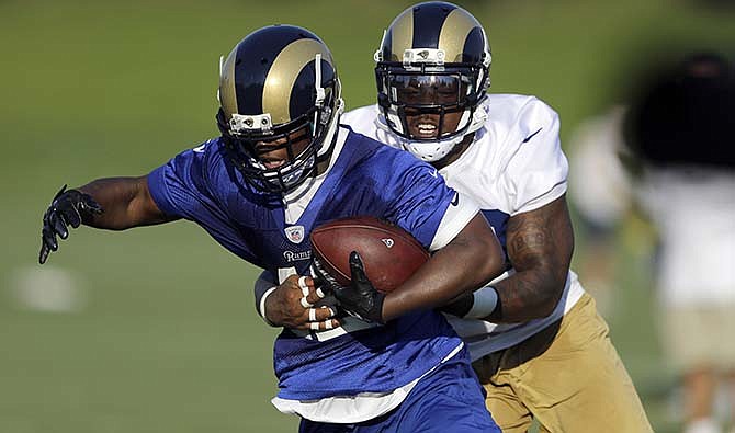 St. Louis Rams running back Trey Watts catches a pass as linebacker Daren Bates defends during training camp at the NFL football team's practice facility Sunday, Aug. 2, 2015, in St. Louis. 