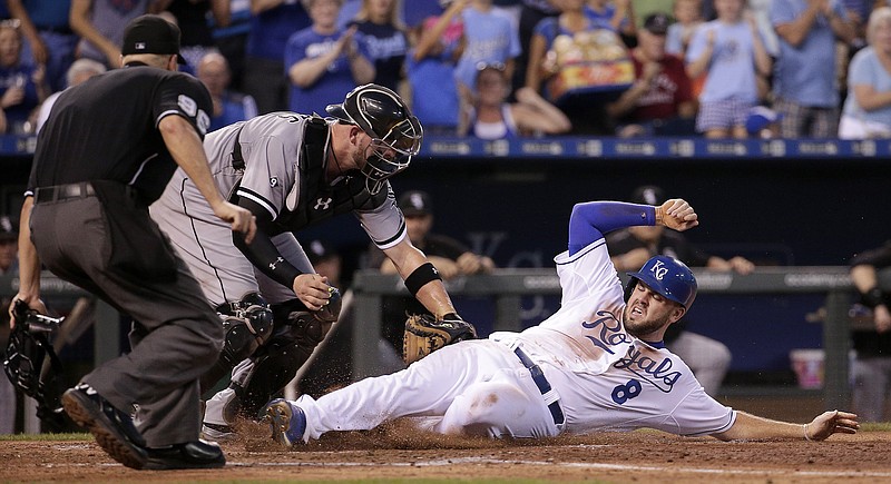 The Royals' Mike Moustakas beats the tag at home by White Sox catcher Tyler Flowers to score on a triple by Alex Rios during the fifth inning of Friday's game in Kansas City.