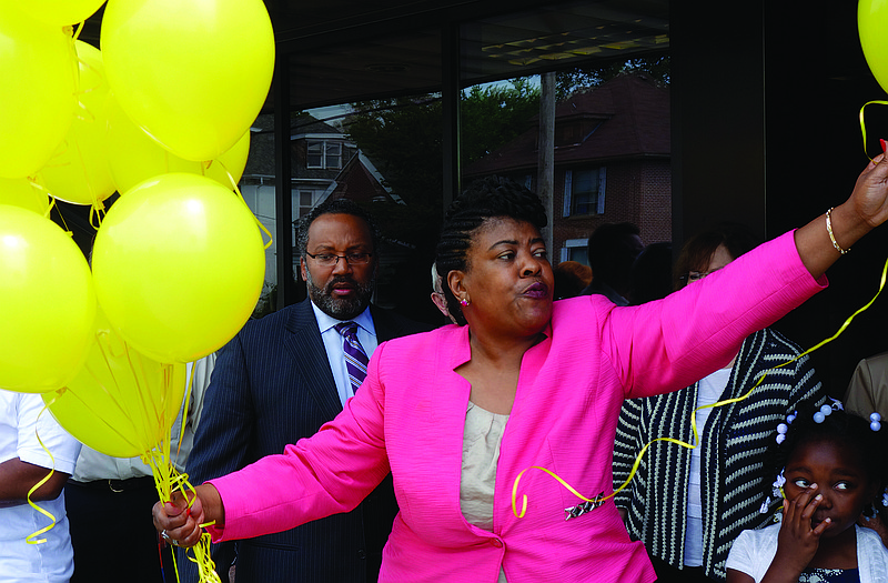Rev. Cassandra Gould, pastor of Quinn Chapel AME Church, passes out balloons on Sunday during a ceremony marking the one-year anniversary of the fatal shooting of Michael Brown in Ferguson.