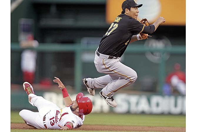 St. Louis Cardinals' Matt Carpenter (13) successfully breaks up a double play as Pittsburgh Pirates shortstop Jung Ho Kang makes a late throw to first in the first inning of a baseball game, Tuesday, Aug. 11, 2015, in St. Louis. 