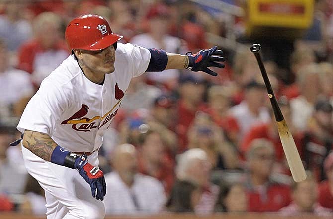 St. Louis Cardinals' Yadier Molina tosses the bat after hitting an RBI triple in the sixth inning of a baseball game against the Pittsburgh Pirates, Wednesday, Aug. 12, 2015, in St. Louis.
