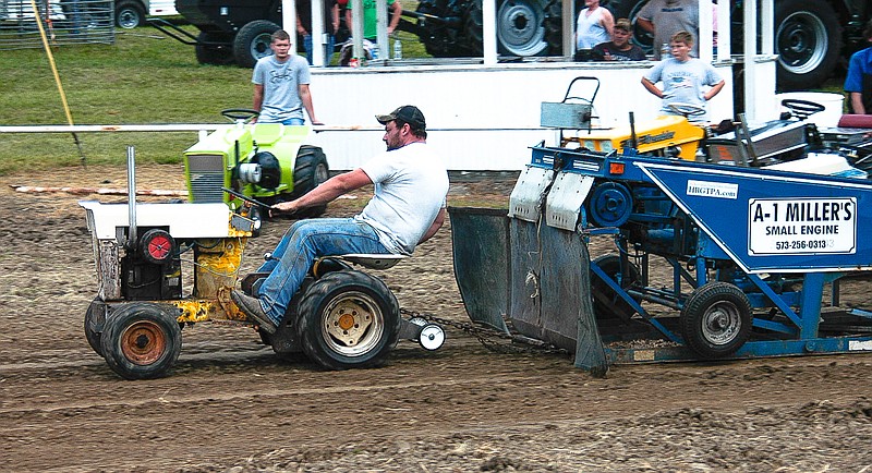 Joe Popejoy leans back to put extra weight over the driving wheels as he pulls the sled at the Hot Rod Garden Tractor Pull.