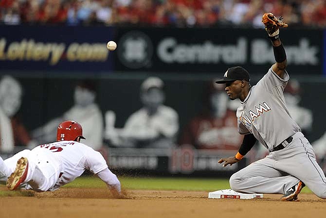 St. Louis Cardinals' Randal Grichuk (15) slides safely into second as Miami Marlins' Adeiny Hechavarria can't handle the throw during the second inning in a baseball game, Friday, Aug. 14, 2015, at Busch Stadium in St. Louis.