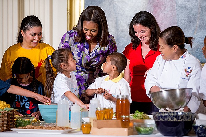 First lady Michelle Obama, accompanied by Lets Move! Executive Director Deb Eschmeyer, second from right, talks with Oneida Gonzalez, 5, center left, and Jefferson Lopez-Martinez, 5, center right, of CentroNia Daycare Center in Washington, D.C., in June as they help prepare food harvested from the White House Kitchen Garden along with fellow children from all over the country who participated in events with the "Let's Move!" campaign, in the East Room at the White House in Washington. 