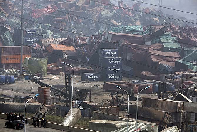 Chinese emergency crew survey the site of an explosion in northeastern China's Tianjin municipality Saturday, Aug. 15, 2015. New explosions and fire rocked the Chinese port city of Tianjin on Saturday, where one survivor was pulled out and authorities ordered evacuations within a 3-kilometer (1.8-mile) radius to clean up chemical contamination.