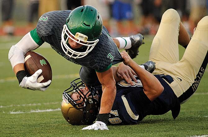 Blair Oaks running back Cody Alexander is tackled by Helias' Nash Harvey as the Falcons and Crusaders face off in a Jamboree Friday at Falcon Athletic Complex in Wardsville, Mo.