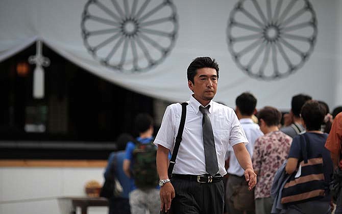 In this Aug. 13, 2015 photo, Hidetoshi Tojo, the great-grandson of Hideki Tojo, the 40th Prime Minister of Japan during World War II, walks after offering a payer at Yasukuni Shrine in Tokyo. The shrine enshrines war criminals, including wartime leader Hideki Tojo, among the 2.5 million war dead.