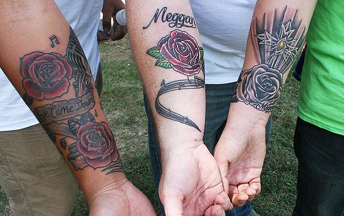 Zeph McDaniel (left), Miriah McDaniel's brother, shows off a tattoo he had done in his sister's memory at a Saturday fundraiser for the families of the three teenagers who were killed in a car accident on August 1. David Fowler (center) and his son Austin Fowler got tattoos in memory of Meggan Fowler who was also killed in the accident. Matt McDaniel (not shown) went with Austin and Zeph to get tattoos from Eric "Papa Lik" Waldrop, whose niece went to school with Meggan, at The Ink Sling Studio in Jefferson City on Friday.