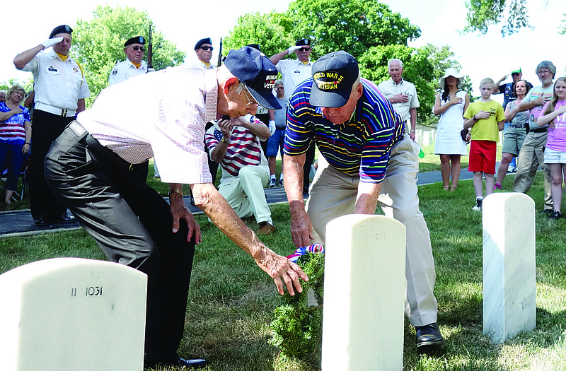 World War II veterans Norbert Bernskoetter, left, and Pete Adkins lay a wreath on the grave of Nelson Bennett in memory of all who were killed in WWII during a National Cemetery ceremony on Sunday commemorating the 70th anniversary of end of the war.