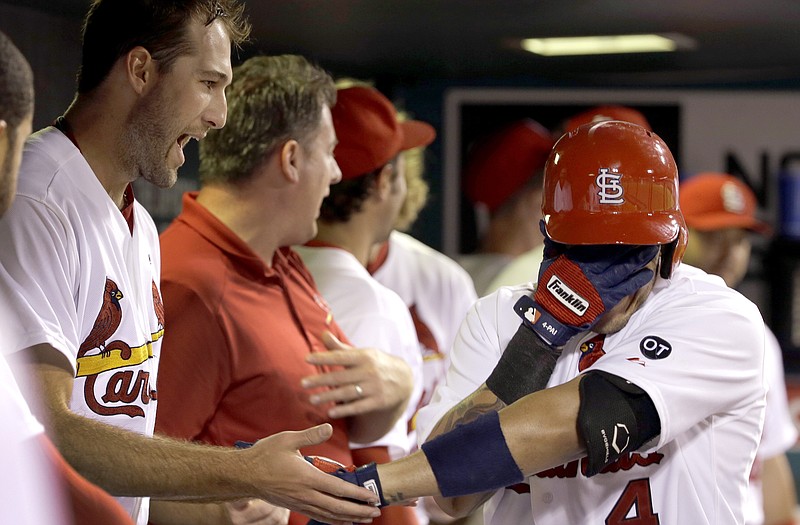 Yadier Molina covers his face as he is congratulated by Cardinals teammate Michael Wacha after hitting a solo home run during the fourth inning of Monday night's game against the Giants at Busch Stadium.