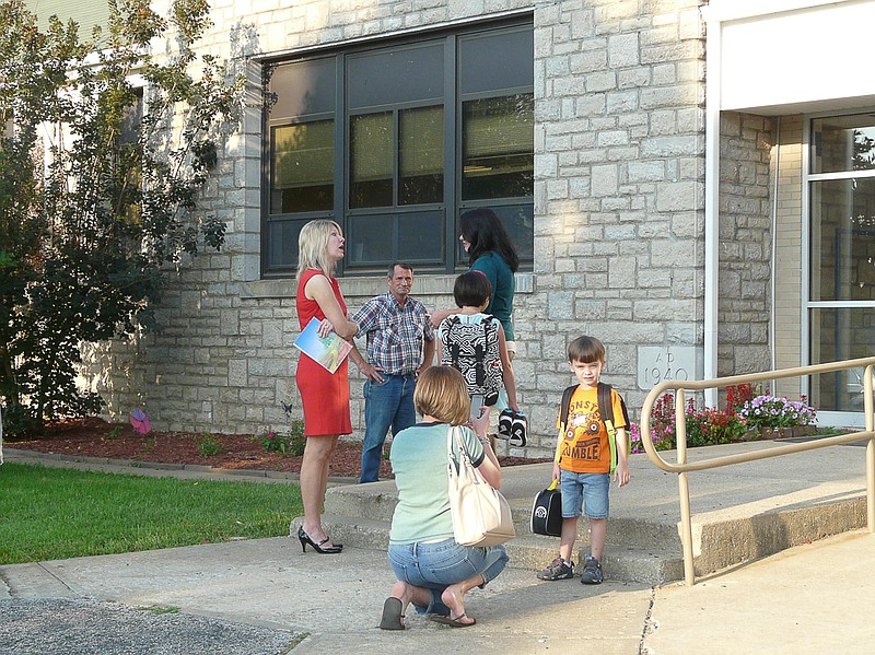 The front of the school was the place to be on Monday, Aug. 17, as Jamestown C-I began classes. A mom snaps a first day of school photo while Superintendent Ellen Ash speaks with a parent as Dale Ashley watches for buses to arrive.