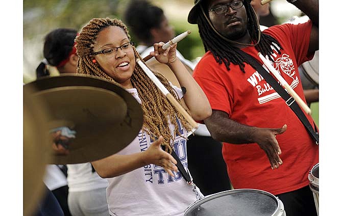 Snare drummer Kayla Coates, left, and her Lincoln University Marching Musical Storm bandmates on the drumline
warm up outside Richardson Hall before the start of the band's halftime show practice on Wednesday afternoon.