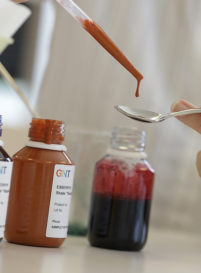 A GNT employee deposits carrot extract on to a spoon at their offices in Tarrytown, New York. Several major food makers are hoping to win over customers by vowing to rid their products of artificial ingredients. 