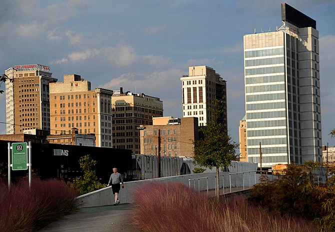 This 2012 photos shows buildings behind Railroad Park in downtown Birmingham, Alabama. Clusters of landlocked municipalities more than 100 miles from the Gulf Coast, including Birmingham which is more than 200 miles away, have secured millions of dollars in BP money through settlements designed to compensate local governments for lost tourism dollars and other economic damage from the company's 2010 oil spill.
