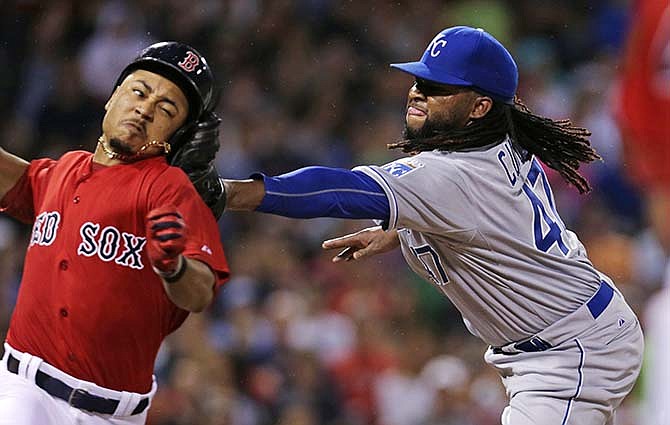 Kansas City Royals starting pitcher Johnny Cueto applies the tag to the head of Boston Red Sox's Mookie Betts as he attempts to leg out a single on a grounder during the sixth inning of a baseball game at Fenway Park in Boston, Friday, Aug. 21, 2015. 