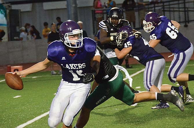 Camdenton quarterback Dyllan Decker attempts to evakde a tackle during Jamboree action last Friday in Columbia.