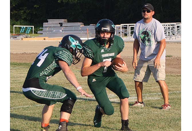 
While Thunderbirds assistant coach Ronnie Kimbley watches, North Callaway
senior safety Tyler Mattes (left) works on his tackling technique against
junior quarterback Milo Henry.
