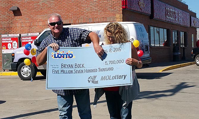 Bryan Bock and his girlfriend Joyce Schokker were awarded a mock check for the
$5.7 million dollars they won in the Missouri Lotto, of which Bock is pointing out
during the press conference in front of the Casey's store in Versailles, Mo., where he
bought the ticket.
