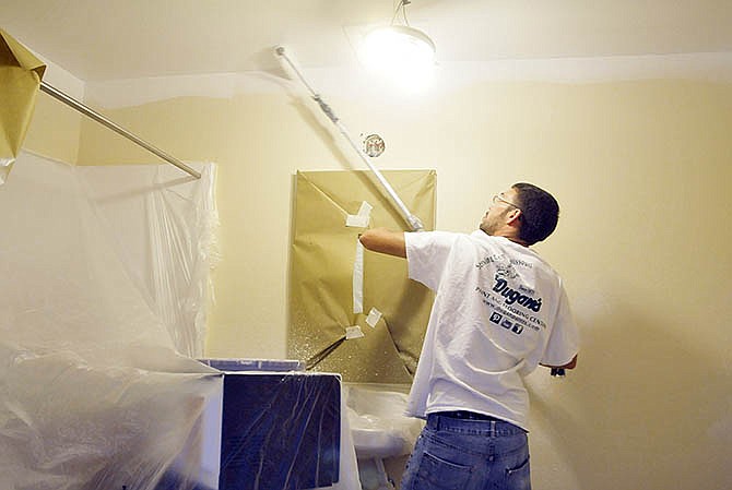 Scott Cambridge of
Barklage Painting in Lake
Ozark, Mo., rolls paint onto the
ceiling in one of the rooms
at Candlewood Suites in
western Jefferson City. The
hotel is undergoing major
remodeling in which it is
getting a new coat of paint,
both inside and out, new
room furniture including
headboards, new carpet and
new kitchen cabinets.